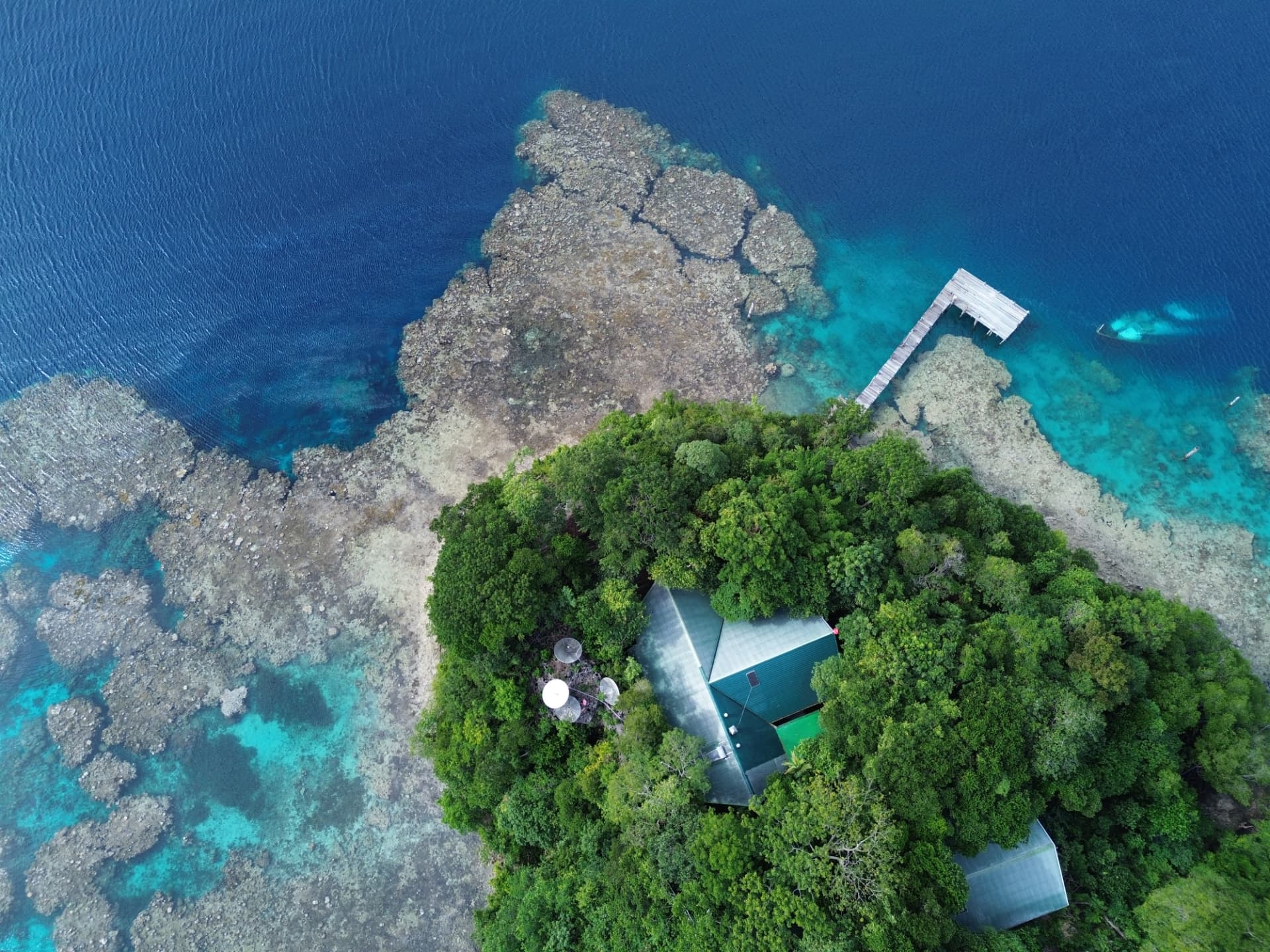 Aerial view of Tawali Resort surrounded by coral reef and turquoise water
