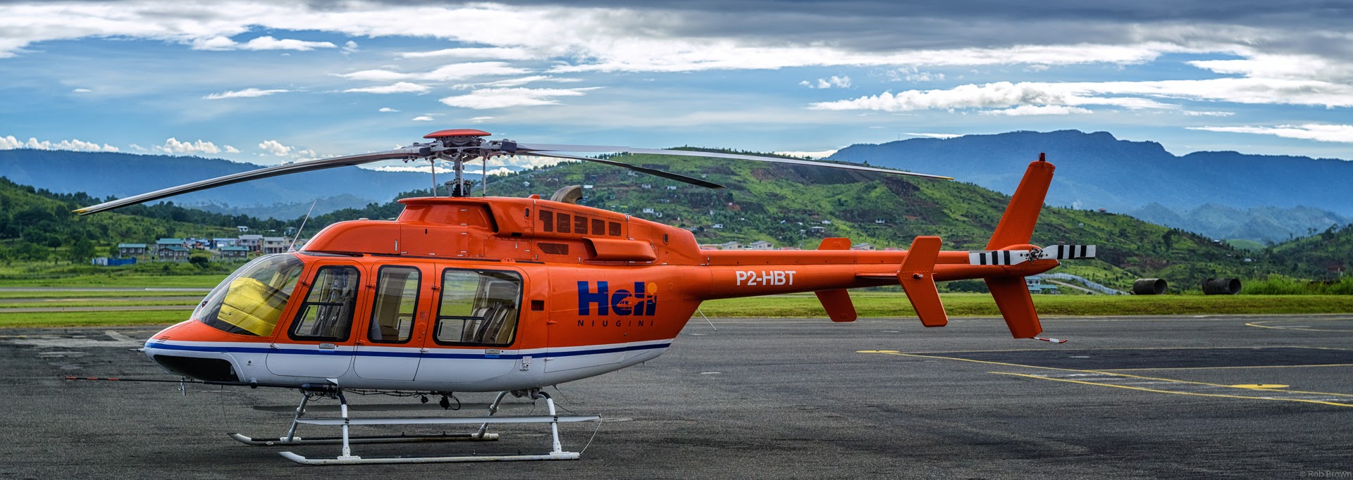 Orange Bell 407 helicopter on the tarmac in Papua New Guinea
