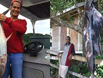 Guests holding large sailfish and trevally caught off Tawali